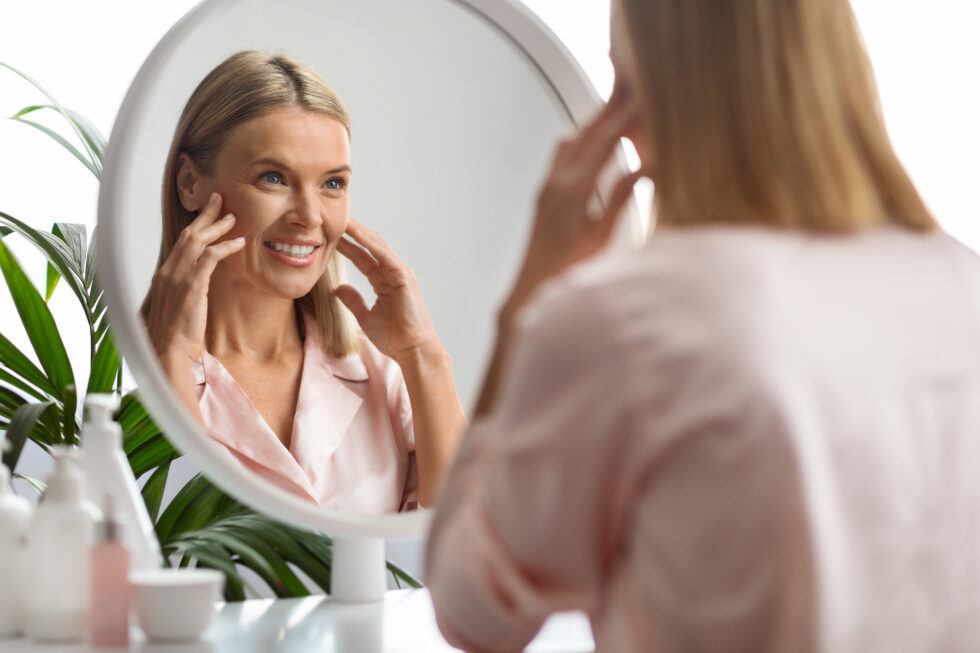 woman looking in mirror at how youthful she is